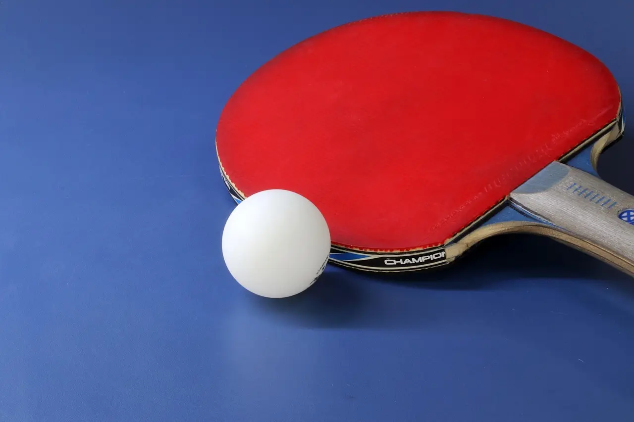 Bordtennisbat med rød gummi og bold